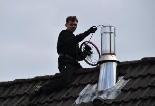 man in black jacket sitting on roof during daytime